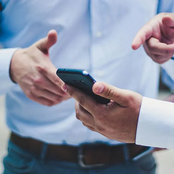 Two people in shirts looking at a smartphone together